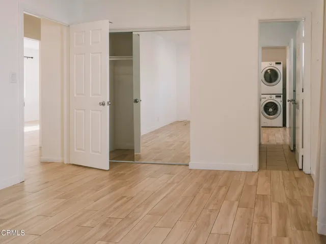 an empty room with wooden floor and closet