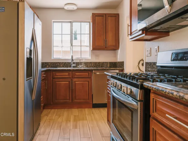 a kitchen with stainless steel appliances granite countertop a stove a sink and a refrigerator