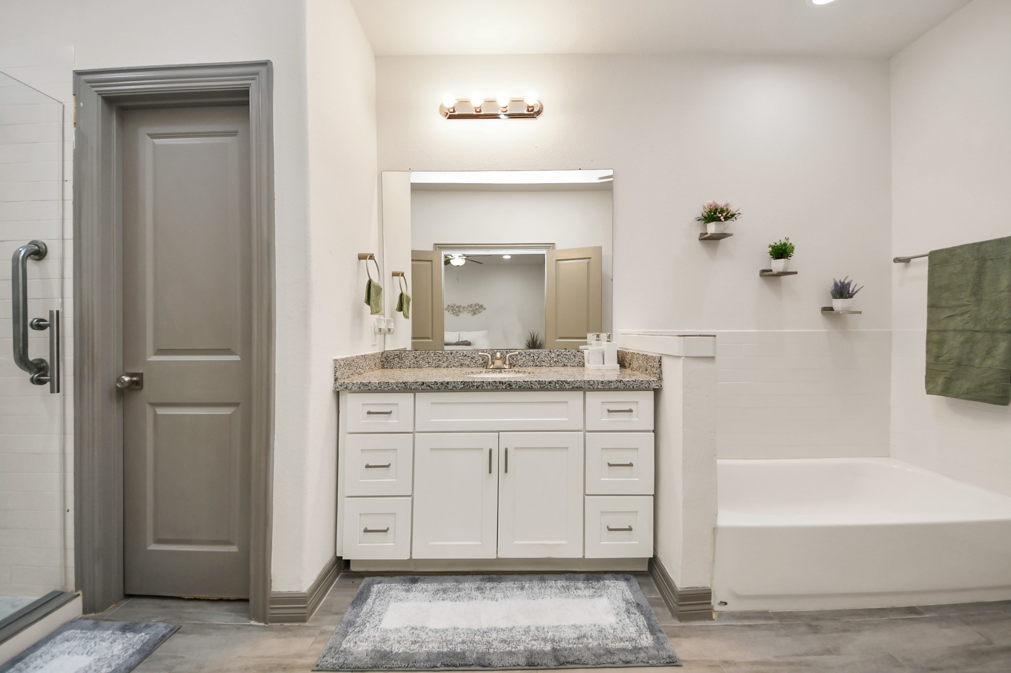 5334 Pershing Street Houston, TX 77033 - Photo 9 of 43 a bathroom with a granite countertop sink a mirror and a bathtub