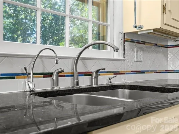 a view of a kitchen sink with granite countertop a large window