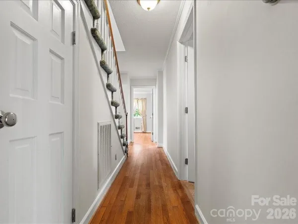a view of a hallway with wooden floor and staircase