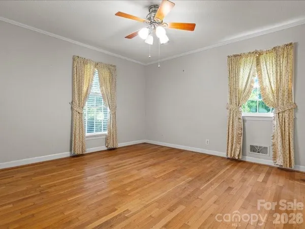 an empty room with windows and cabinet