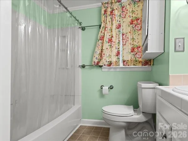 a bathroom with a toilet and a shower curtain