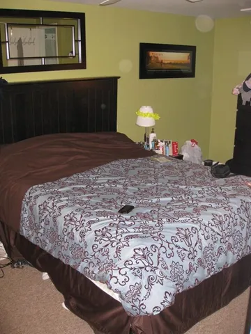 a bed sitting in a bedroom next to a wall