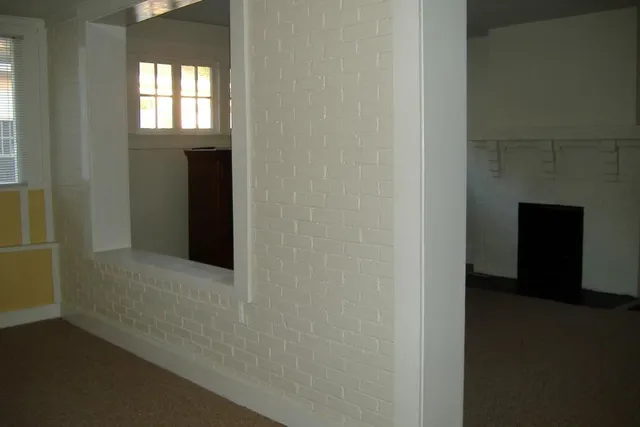 a view of an empty room with a fireplace and a window
