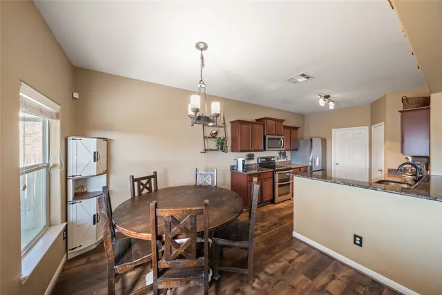 a view of a dining room and livingroom with furniture wooden floor a chandelier