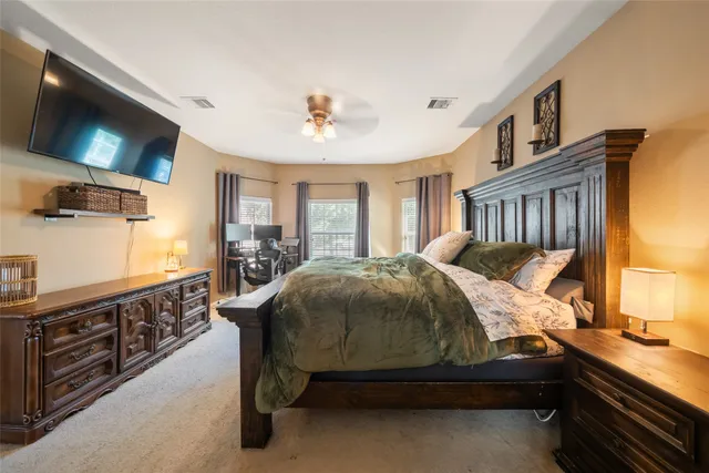 a bedroom with a bed and a flat tv screen on the dresser