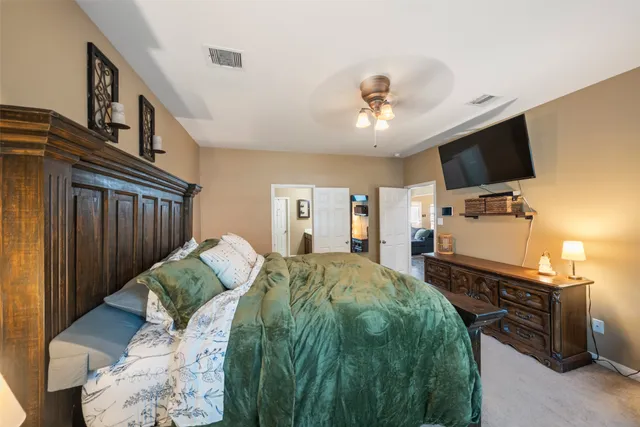 a spacious bedroom with a bed and a flat screen tv