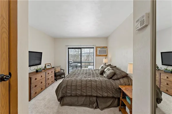 a bedroom with a bed and a flat tv screen on the dresser