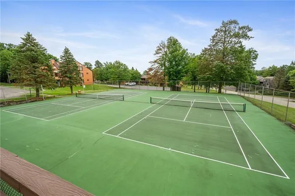 a tennis court with trees in the background