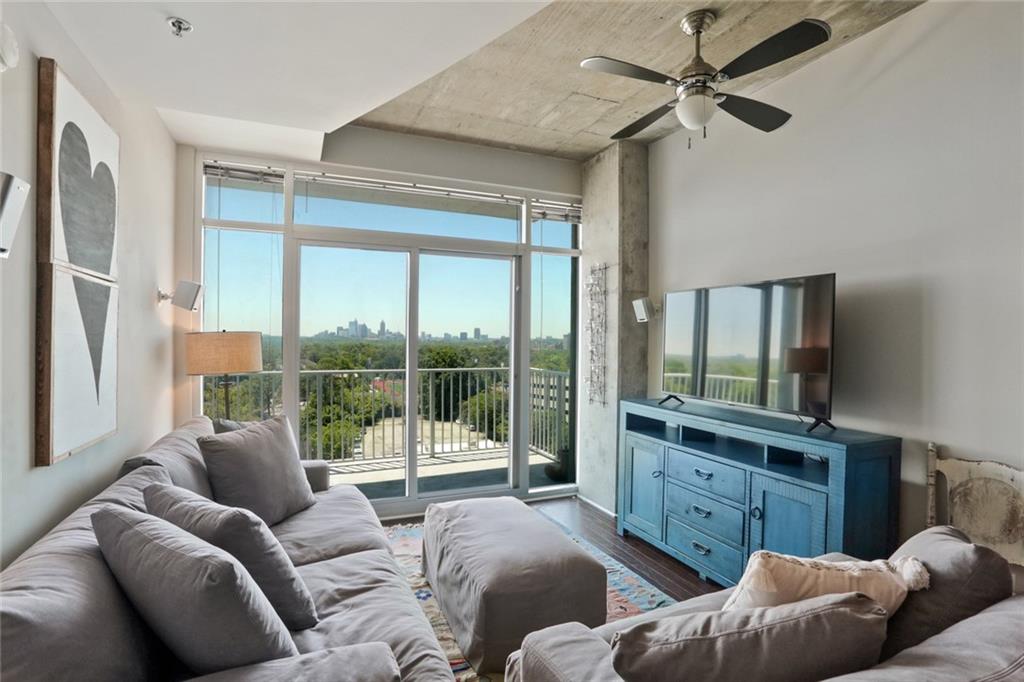 a living room with furniture a large window and a flat screen tv