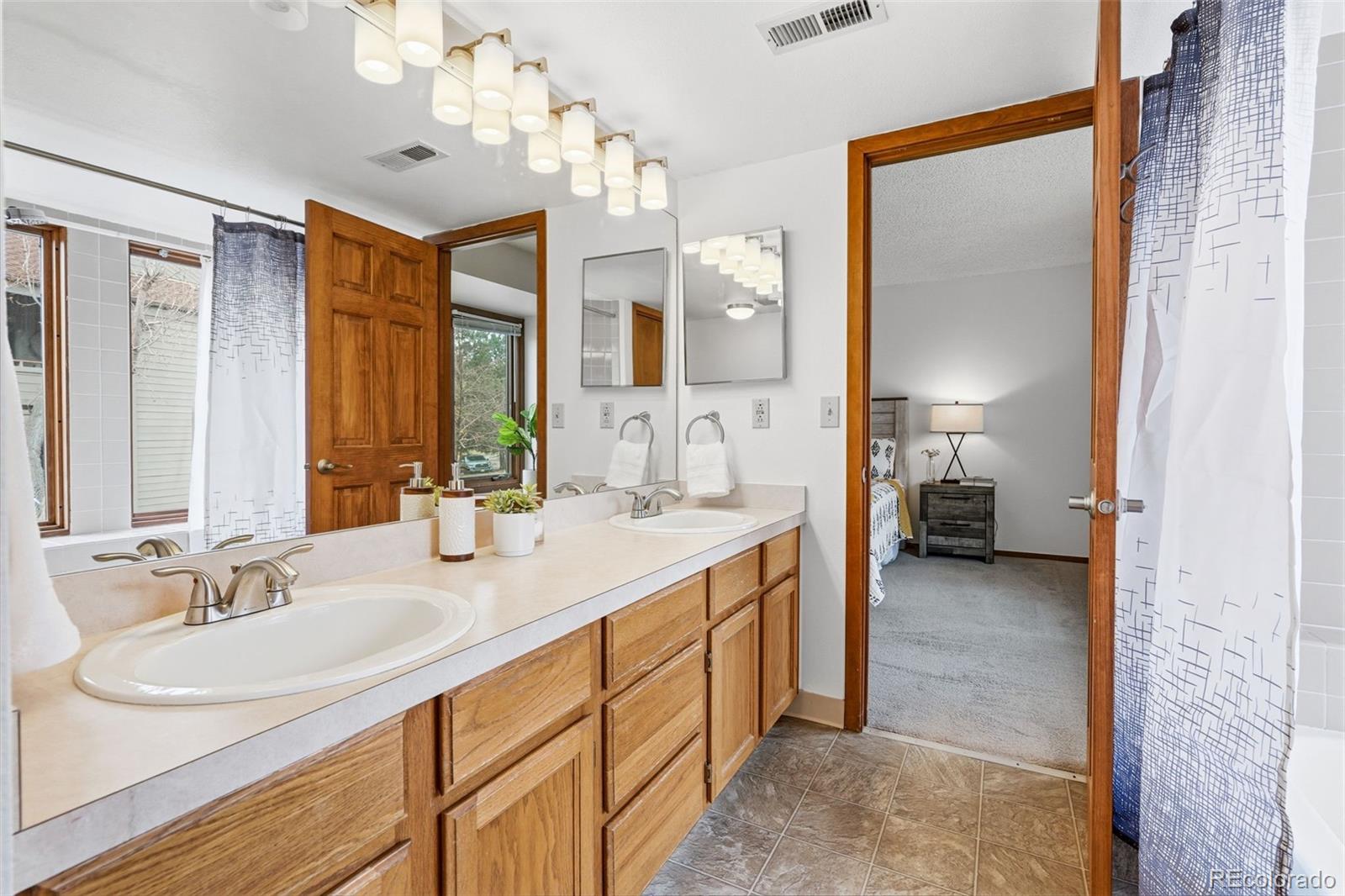 23557 Genesee Village Road, Unit A Golden, CO 80401 - Photo 22 of 38 a bathroom with a sink double vanity and a mirror