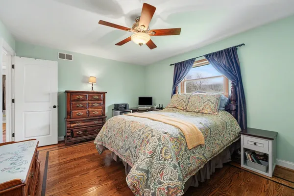 a bedroom with a bed a dresser and a couch