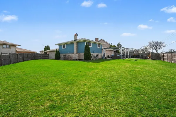 a view of a house with a yard and sitting area
