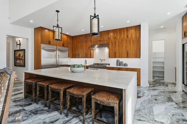 a kitchen with a table chairs sink and cabinets