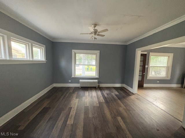 3258 Berkshire Road Cleveland, OH 44118 - Photo 9 of 23 Unfurnished room with plenty of natural light, radiator heating unit, dark wood finished floors, crown molding, and ceiling fan