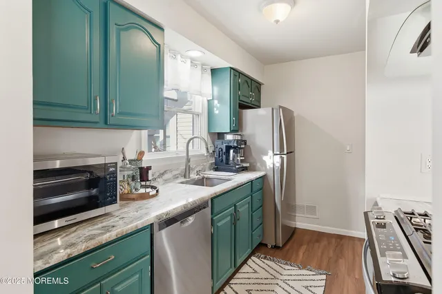 a kitchen with stainless steel appliances granite countertop a sink stove and refrigerator