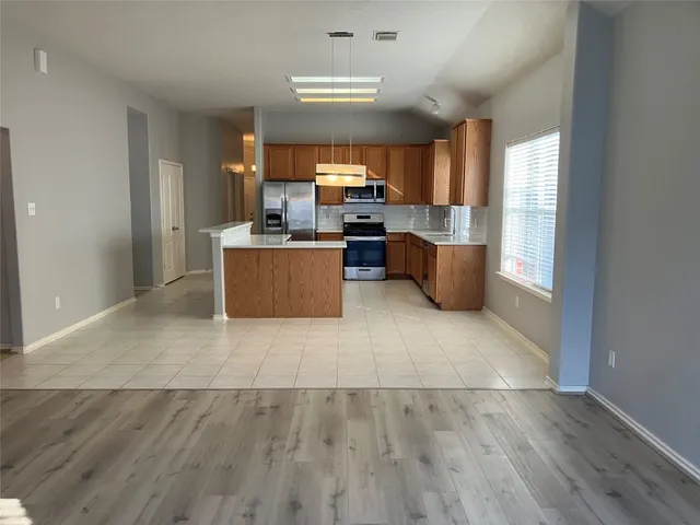 a large kitchen with a lot of counter top space and stainless steel appliances