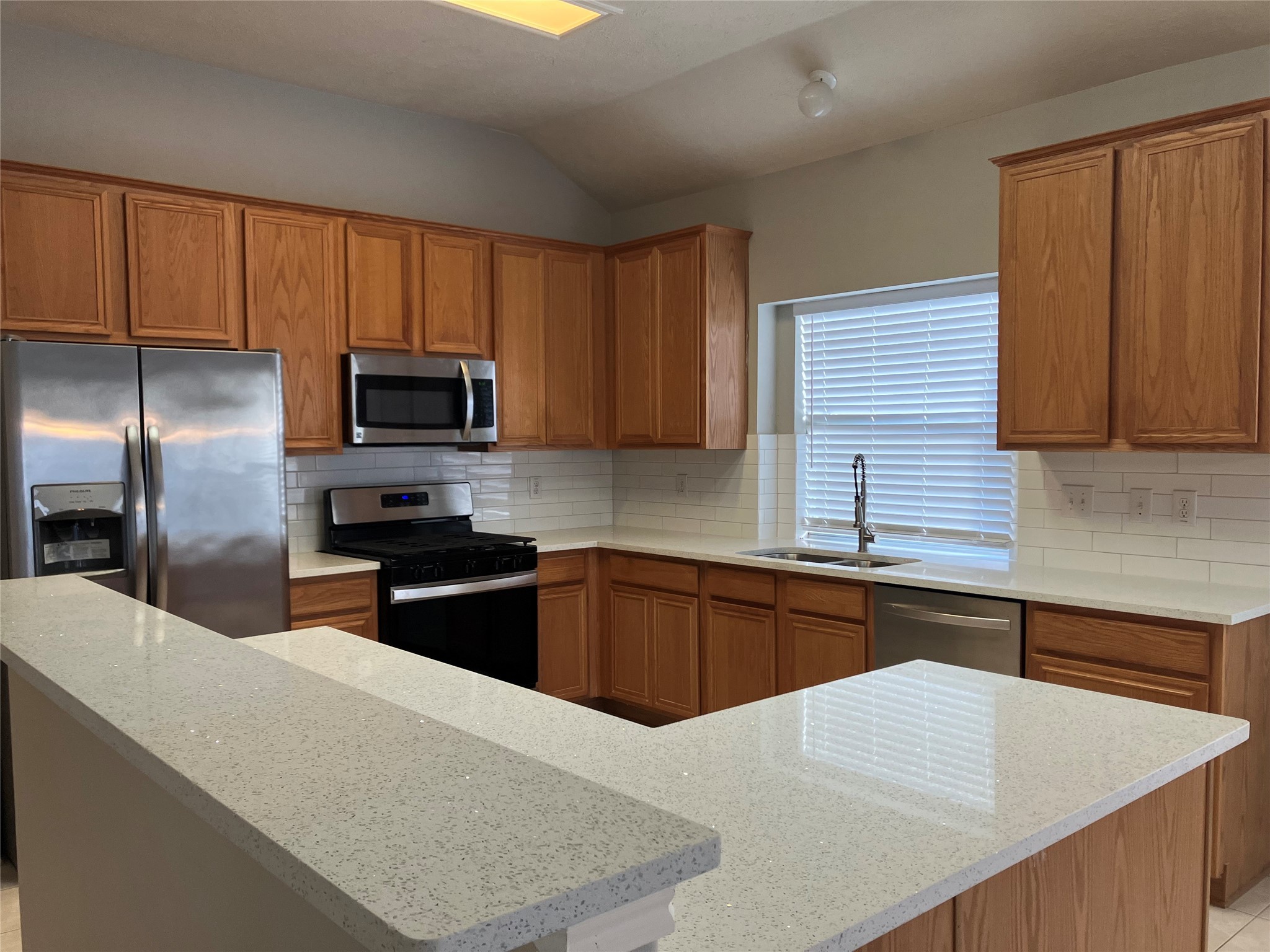3402 Pebble Beach Lane Pearland, TX 77584 - Photo 15 of 31 a kitchen with stainless steel appliances granite countertop a sink stove microwave refrigerator and cabinets