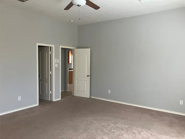 an empty room with chandelier fan