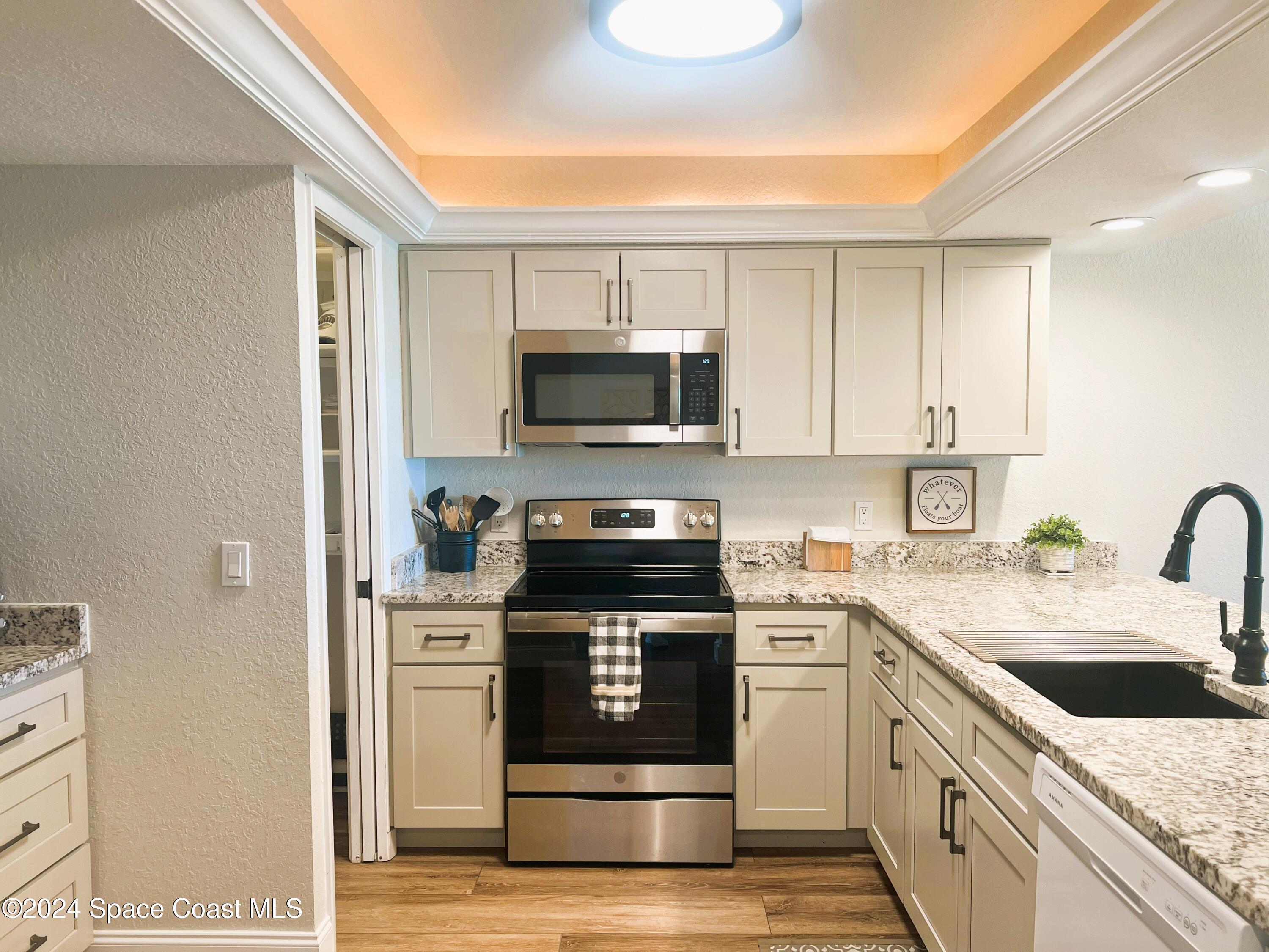 300 South Banana River Boulevard, Unit 305 Cocoa Beach, FL 32931 - Photo 13 of 36 a kitchen with a sink stove and microwave