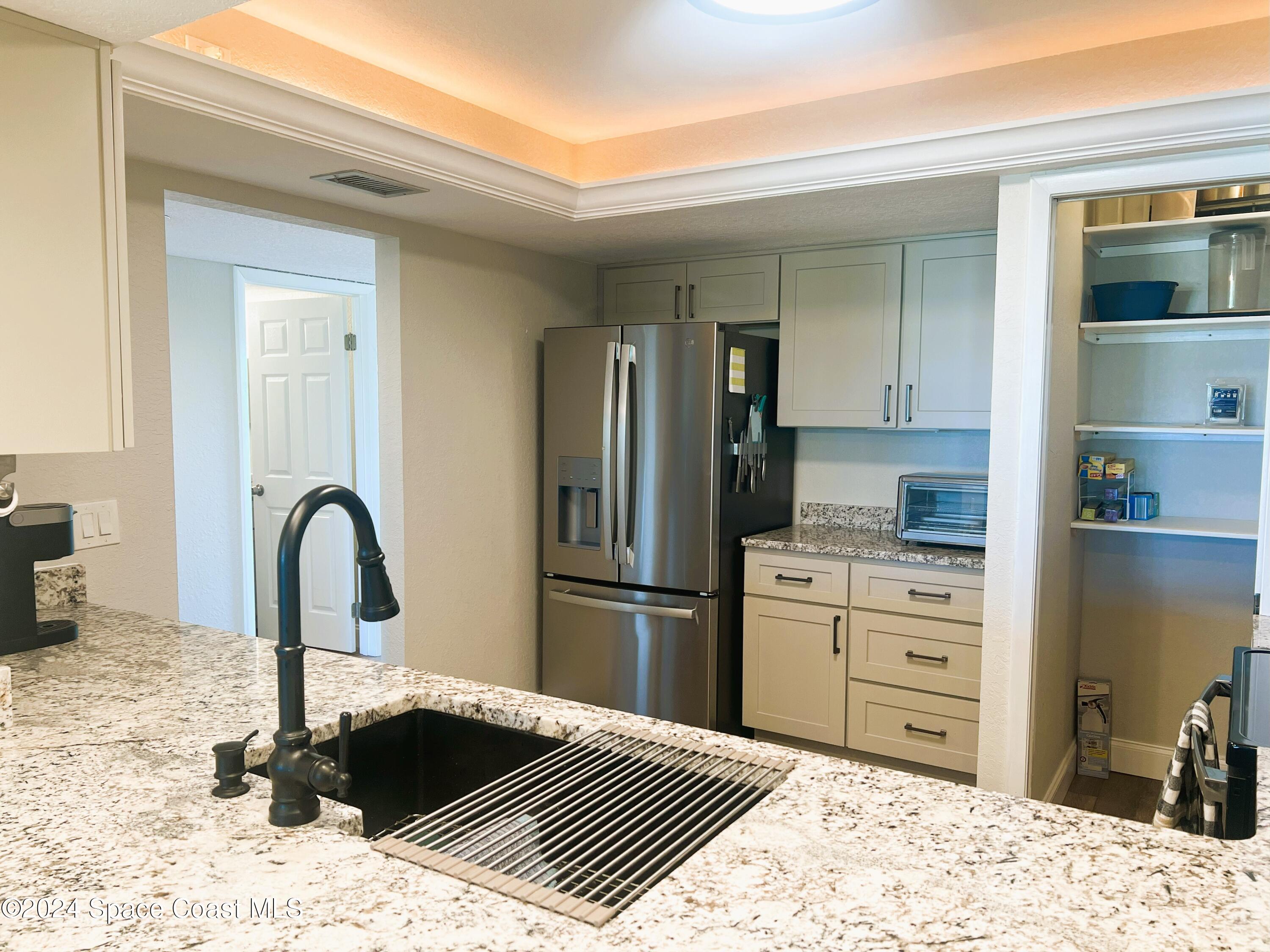 300 South Banana River Boulevard, Unit 305 Cocoa Beach, FL 32931 - Photo 14 of 36 a kitchen with a refrigerator and a sink
