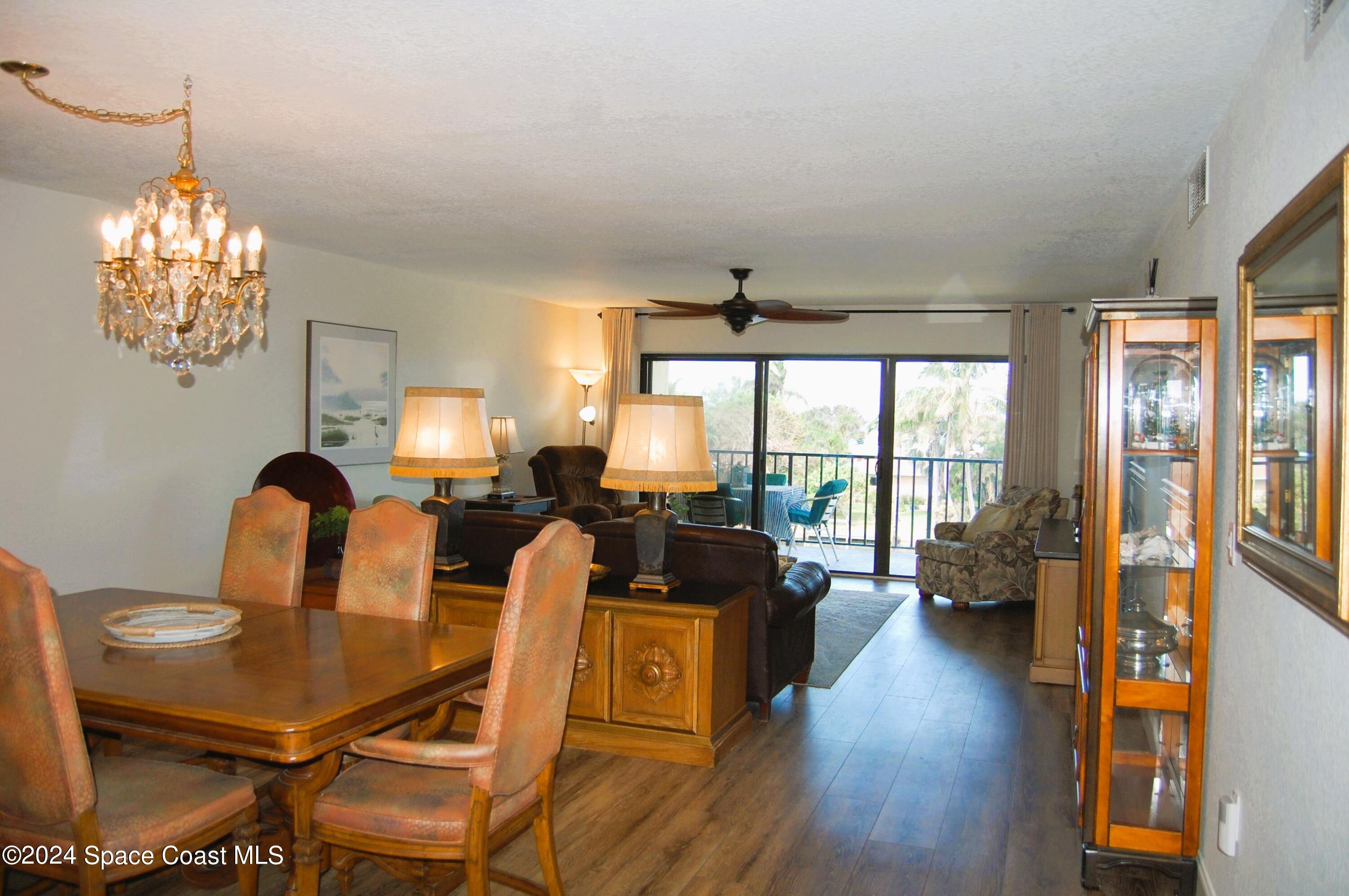 300 South Banana River Boulevard, Unit 305 Cocoa Beach, FL 32931 - Photo 20 of 36 a view of a dining room with furniture a chandelier and wooden floor