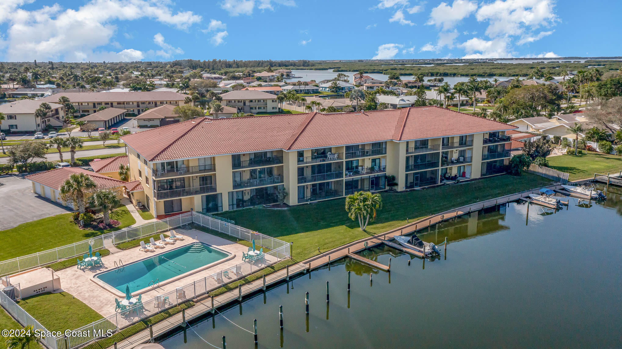 300 South Banana River Boulevard, Unit 305 Cocoa Beach, FL 32931 - Photo 2 of 36 an aerial view of a house with a garden and lake view