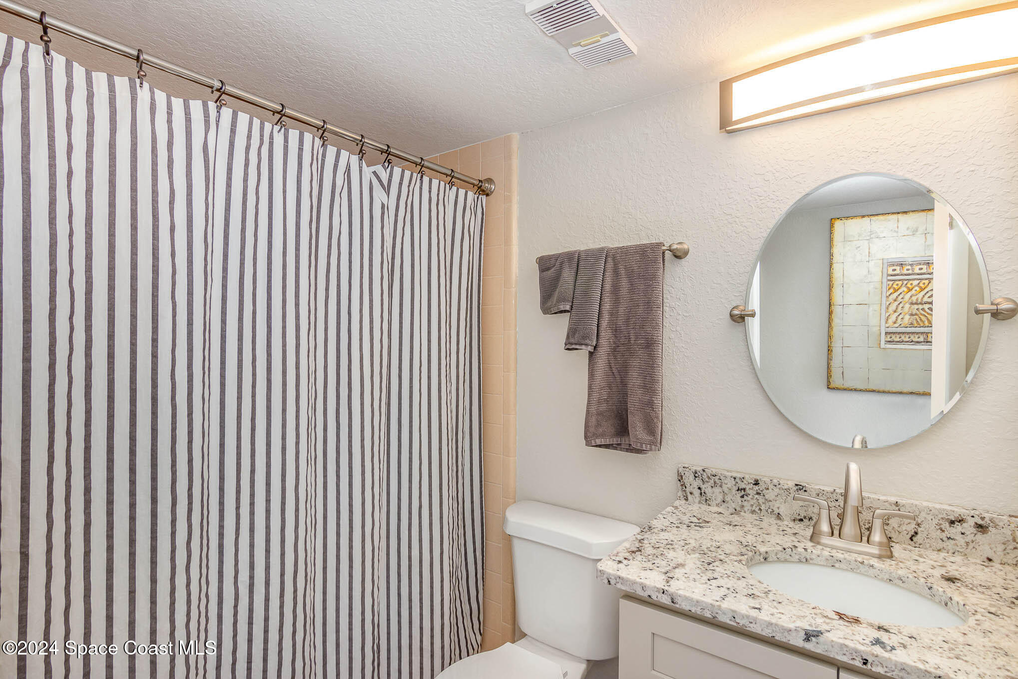 300 South Banana River Boulevard, Unit 305 Cocoa Beach, FL 32931 - Photo 22 of 36 a bathroom with a granite countertop sink a mirror and vanity