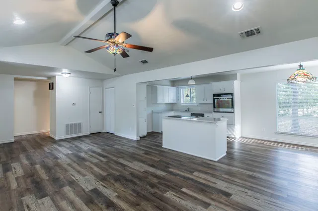 a view of a kitchen with stove and cabinets