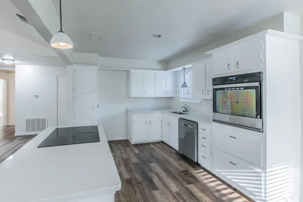 a kitchen with granite countertop white cabinets and stainless steel appliances