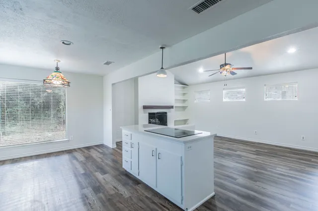 an empty room with a fireplace and wooden floor