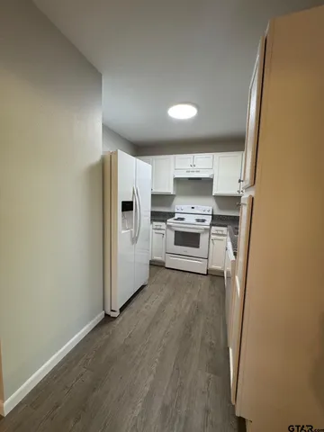 a view of a kitchen with a sink stove refrigerator and cabinets