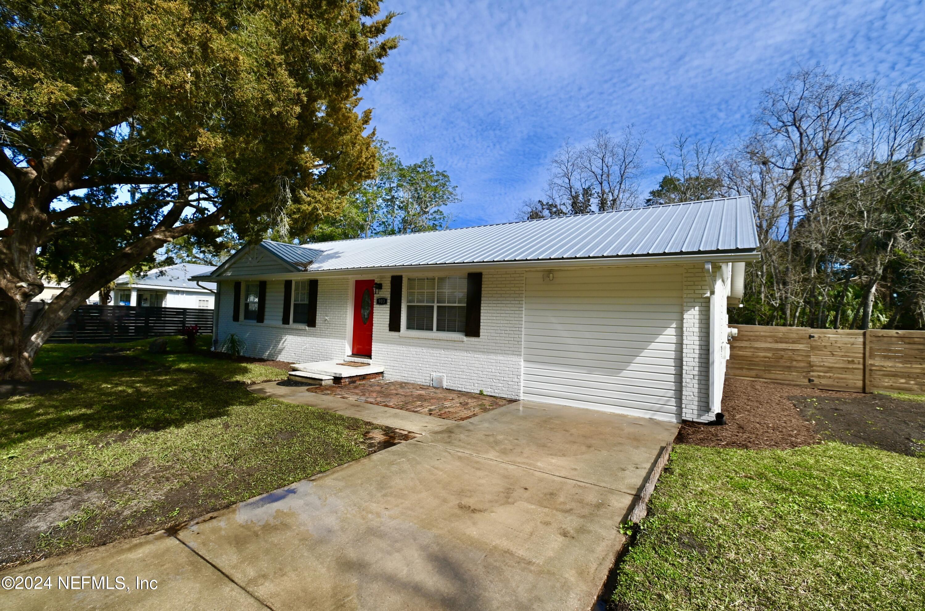 a front view of a house with a yard and trees