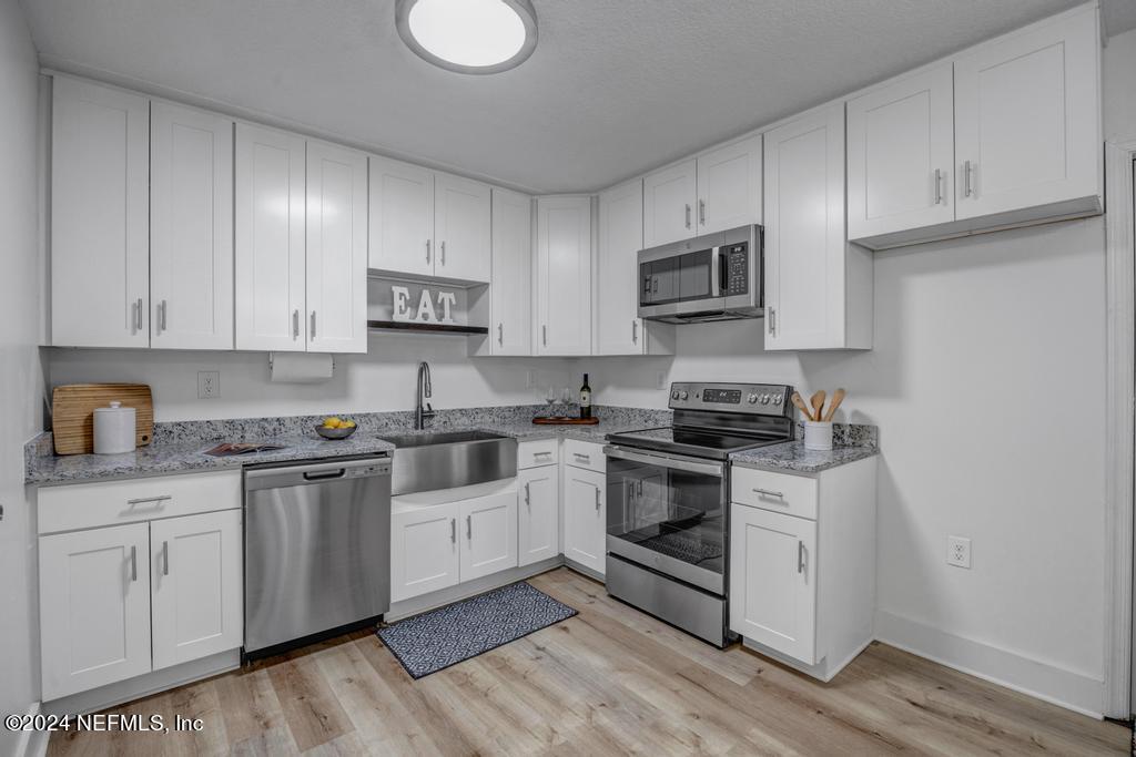 903 Royal Road St. Augustine, FL 32086 - Photo 15 of 32 a kitchen with stainless steel appliances granite countertop a stove a sink and a microwave