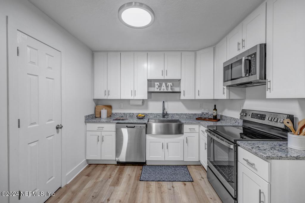 903 Royal Road St. Augustine, FL 32086 - Photo 17 of 32 a kitchen with stainless steel appliances granite countertop a stove a sink and a microwave