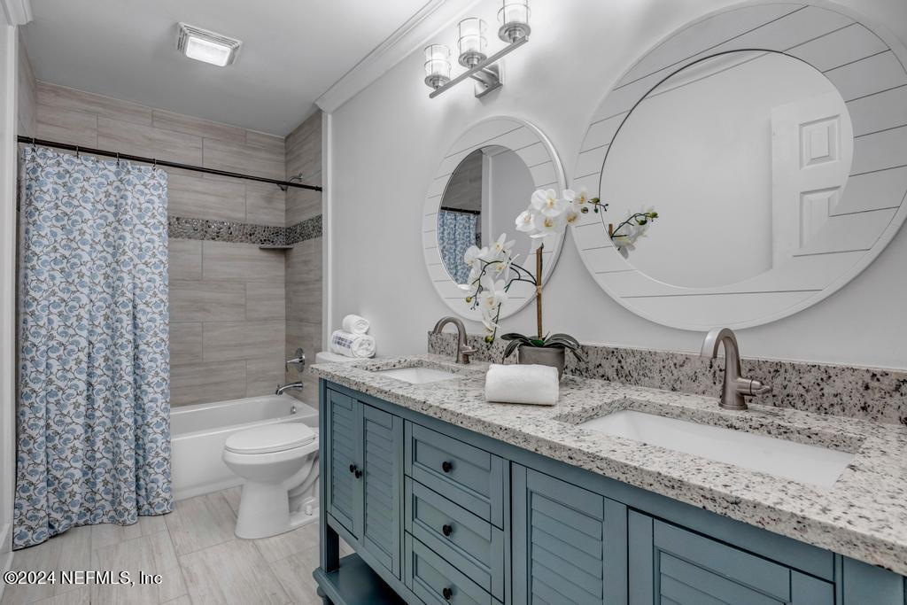 903 Royal Road St. Augustine, FL 32086 - Photo 28 of 32 a bathroom with a double vanity sink toilet and shower