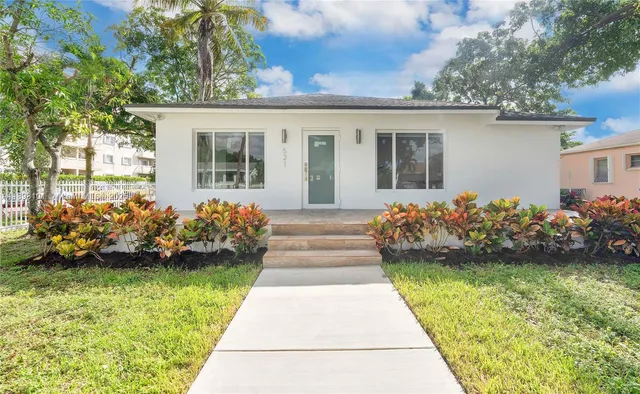 a front view of a house with a garden