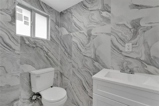 a white toilet sitting next to a bathroom sink