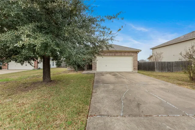 a front view of a house with a yard and trees