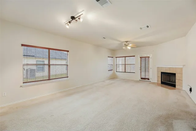 a view of an empty room with a fireplace and a window