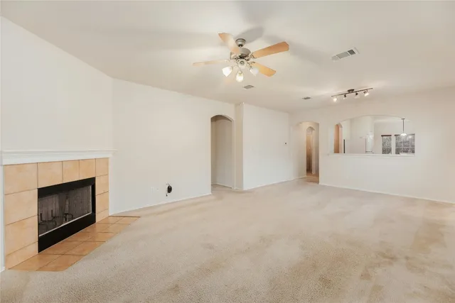 an empty room with fireplace and windows