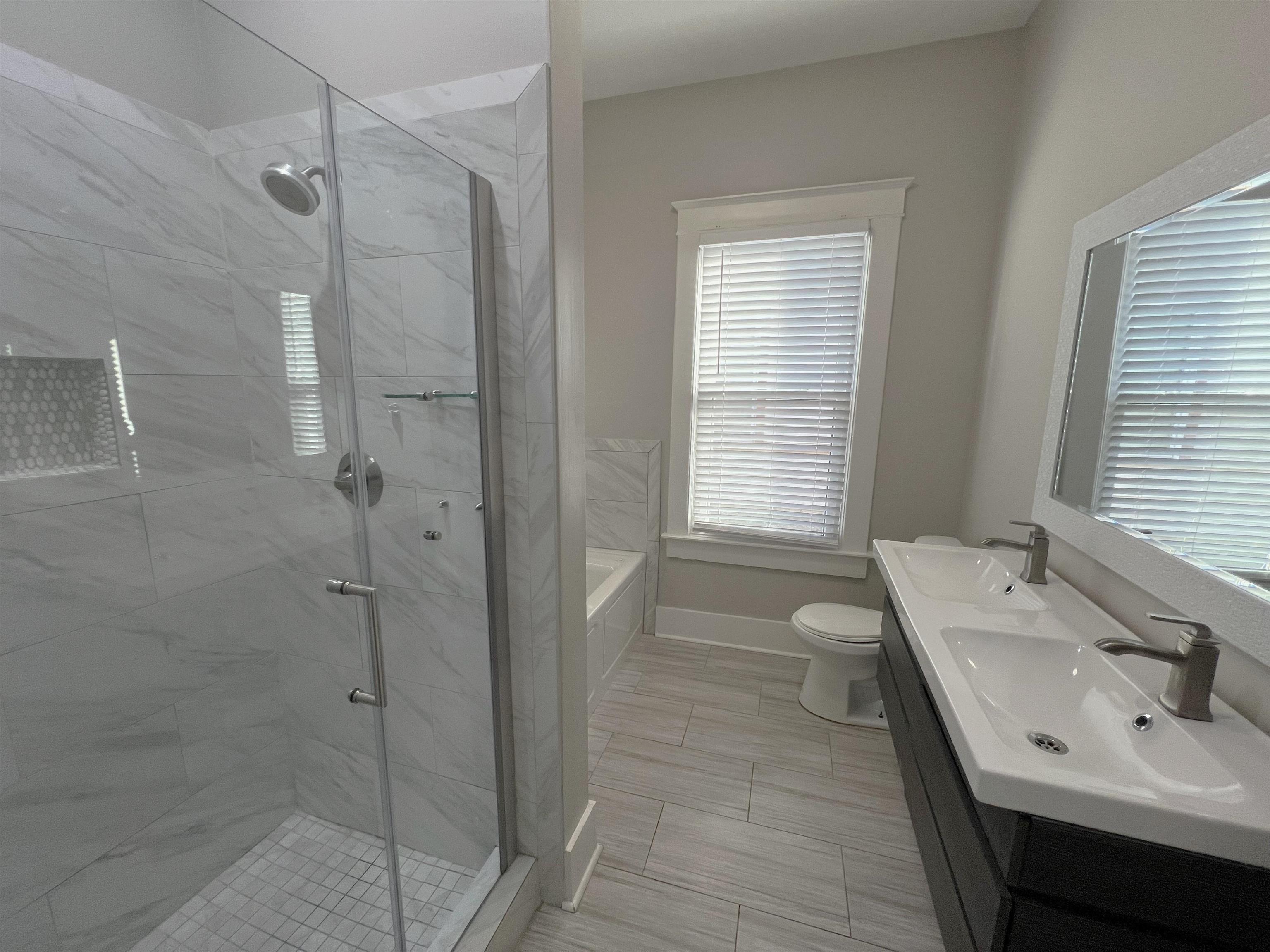 897 South Cox Street Memphis, TN 38104 - Photo 7 of 14 a bathroom with a tub sink and mirror