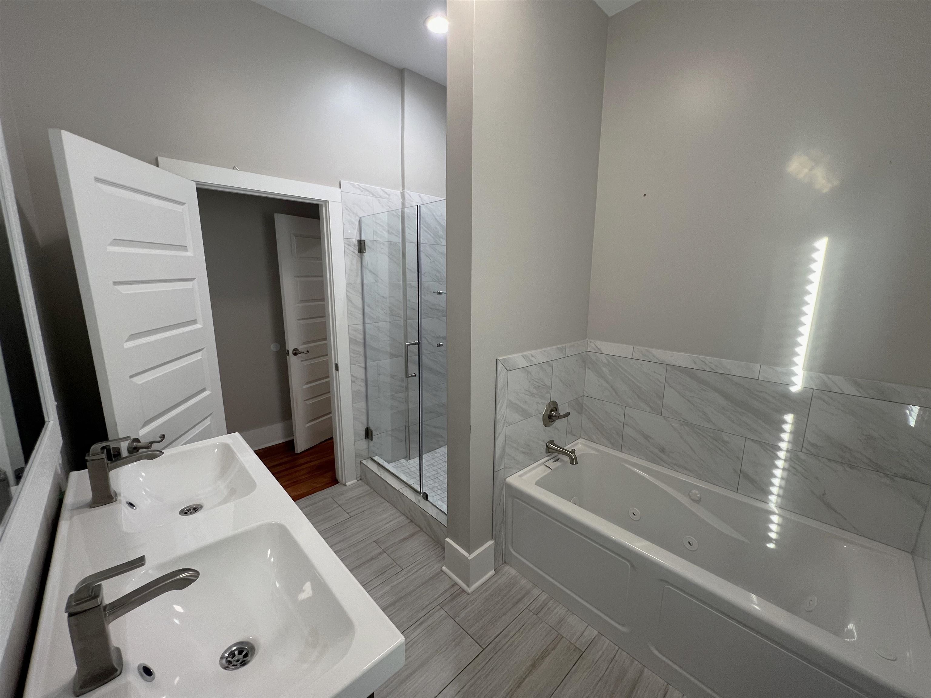 897 South Cox Street Memphis, TN 38104 - Photo 8 of 14 a bathroom with a tub sink and mirror