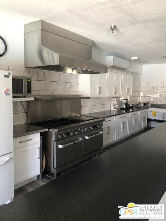 69525 Dillon Road, Unit 73 Desert Hot Springs, CA 92241 - Photo 26 of 48 a kitchen with stainless steel appliances granite countertop a sink a stove and a refrigerator