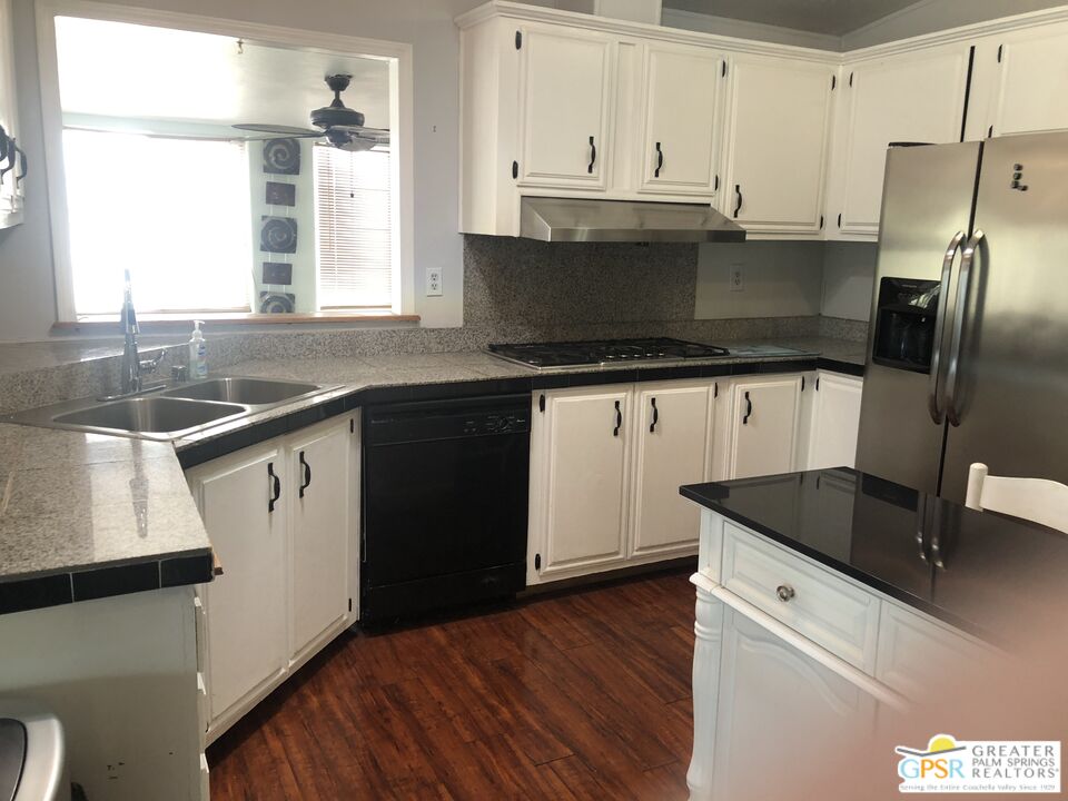 69525 Dillon Road, Unit 73 Desert Hot Springs, CA 92241 - Photo 10 of 48 a kitchen with granite countertop a sink stove and refrigerator