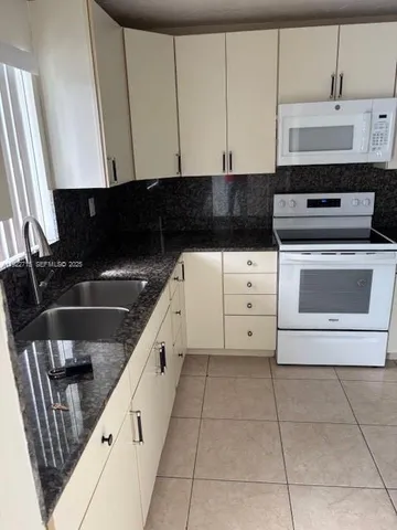 a kitchen with a stove a sink and a microwave