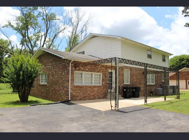 a glass building with yard and in front of it