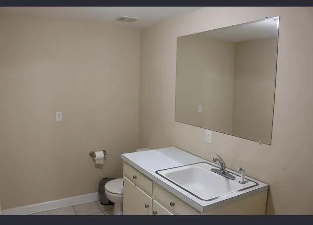 a bathroom with a sink toilet and mirror