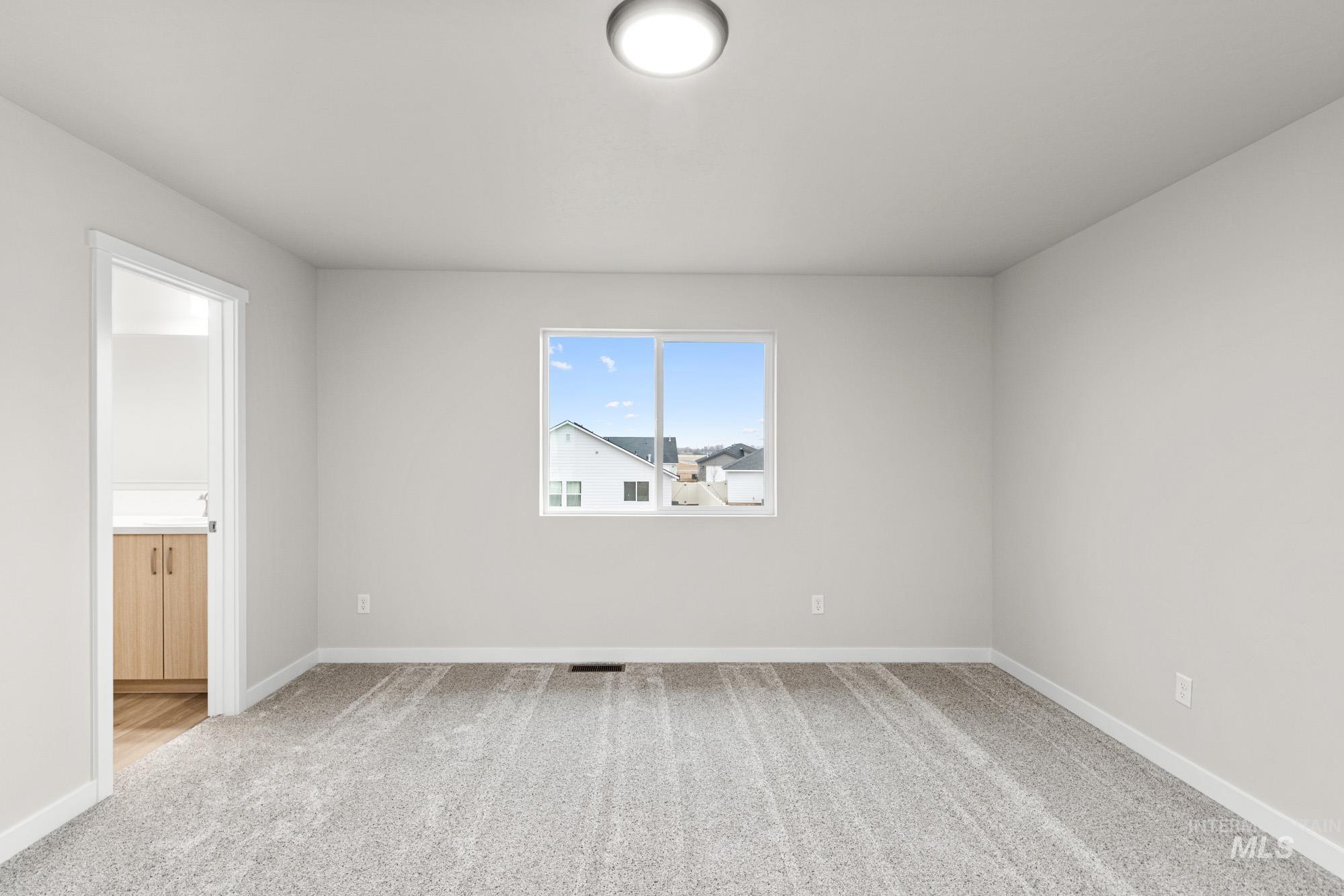 13711 Inman Court Caldwell, ID 83607 - Photo 14 of 16 Empty room with light colored carpet and baseboards